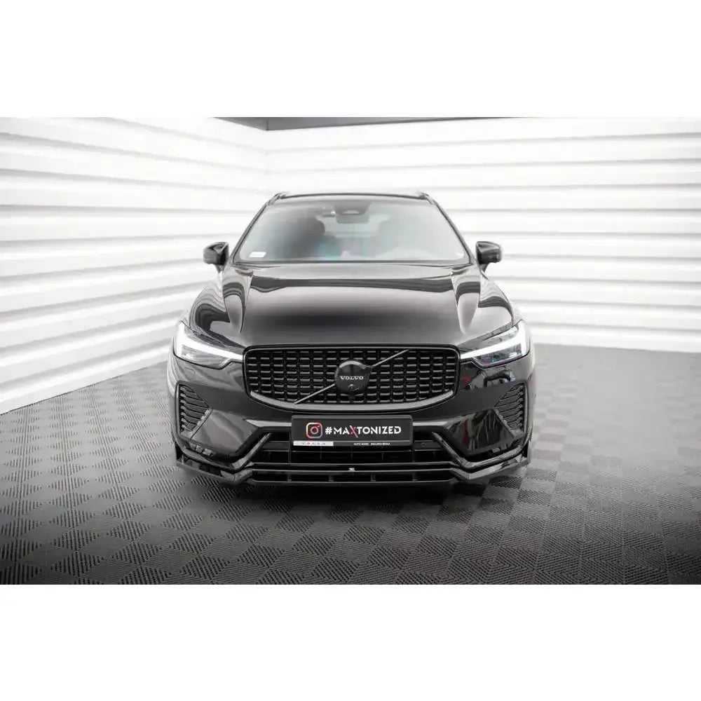 Frontleppe på Volvo XC60 R-Design Mk2 Facelift, sett forfra med sort grill mot hvit vegg.