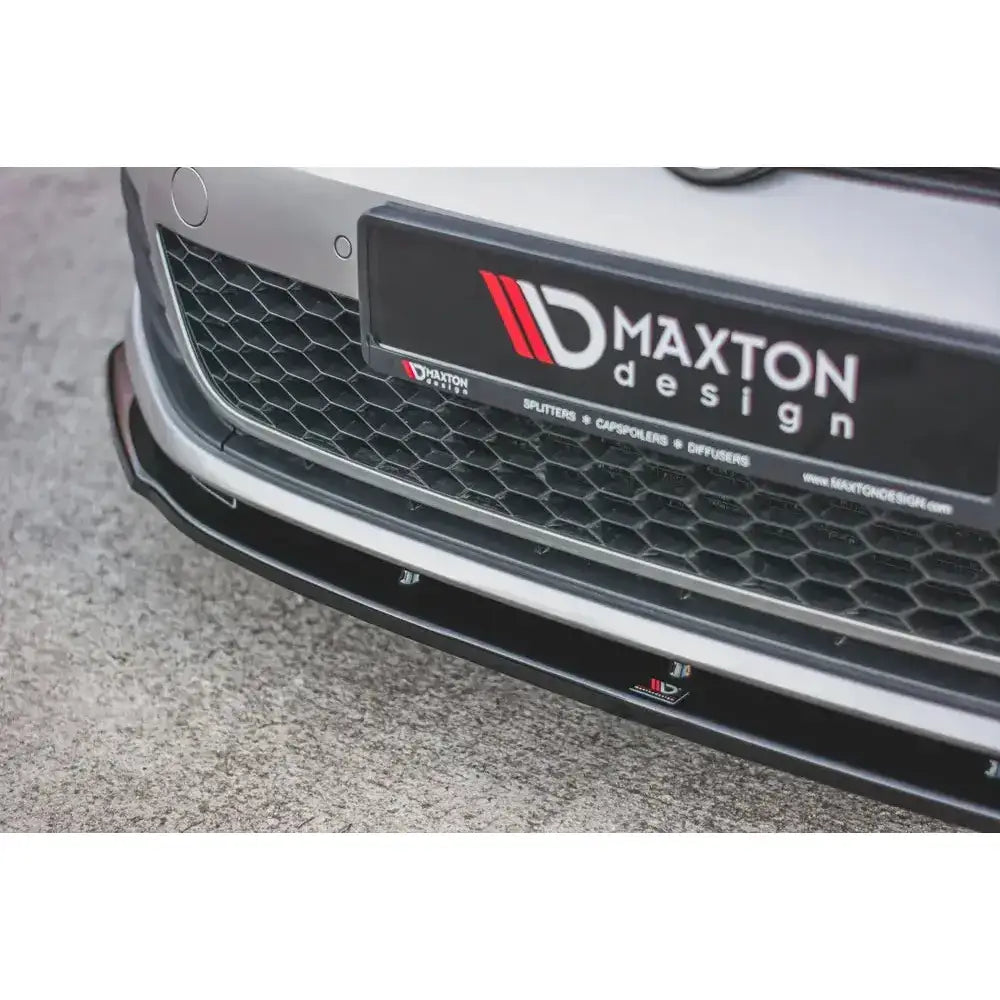 Front splitter på VW Golf VII GTI med sort plastspoiler, bikubemønstret grill og Maxton Design-logo.