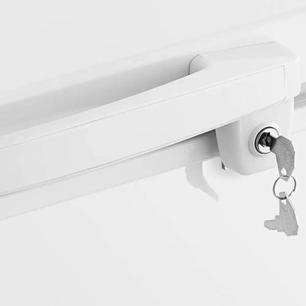 Fryseboksens hvite håndtak fra siden, med sylinderlås og to sølvfargede nøkler hengende i låsen.