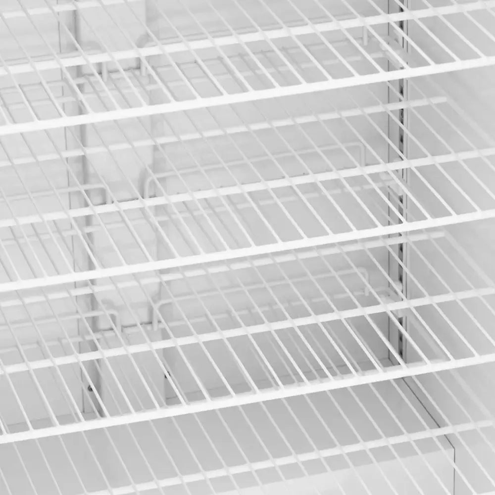 Fryseskap, nærbilde av hvite metallhyller med gittermønster, flere nivåer sett skrått ovenfra.