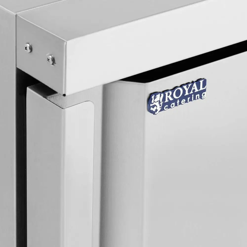 Fryseskap i rustfritt stål, nærbilde av skapets hjørne med synlige skruer og blå Royal Catering-logo.