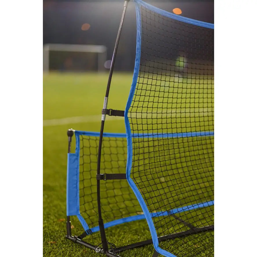 Galaktisk Hoppeseng, sidevisning av svart netting med blå kant og synlige stolpedetaljer på kunstgressbane.