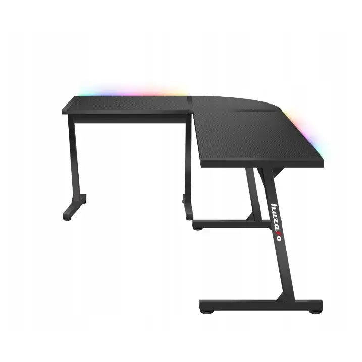 Gaming hjørnebord Huzaro Hero 6.0 RGB, L-formet svart design med RGB-lys og metallramme med logo, sett skrått.