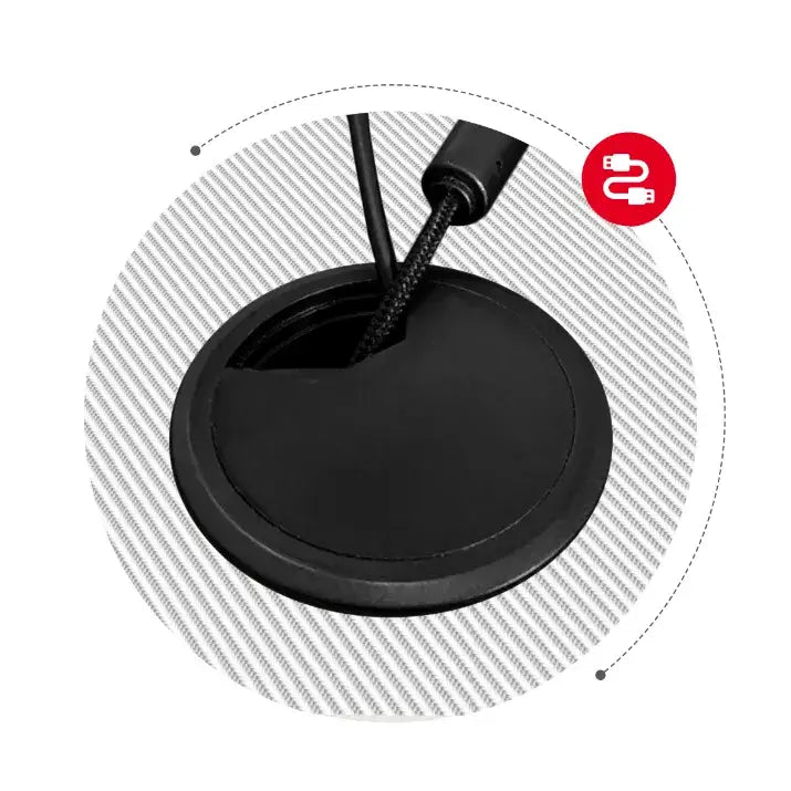 Gaming Hjørnebord Huzaro Hero 6.3, nærbilde av svart kabelgjennomføring med to kabler mot stripete overflate.