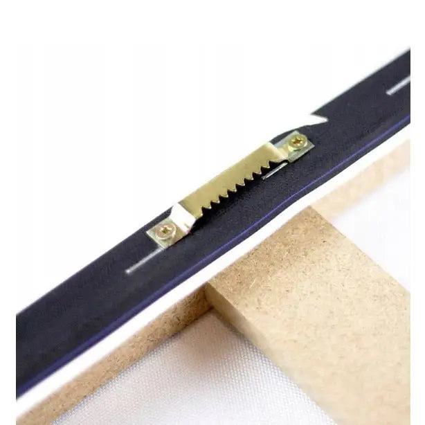 Opphengsbeslag i metall på baksiden av lerretsbilde, festet med skruer til lys treramme.