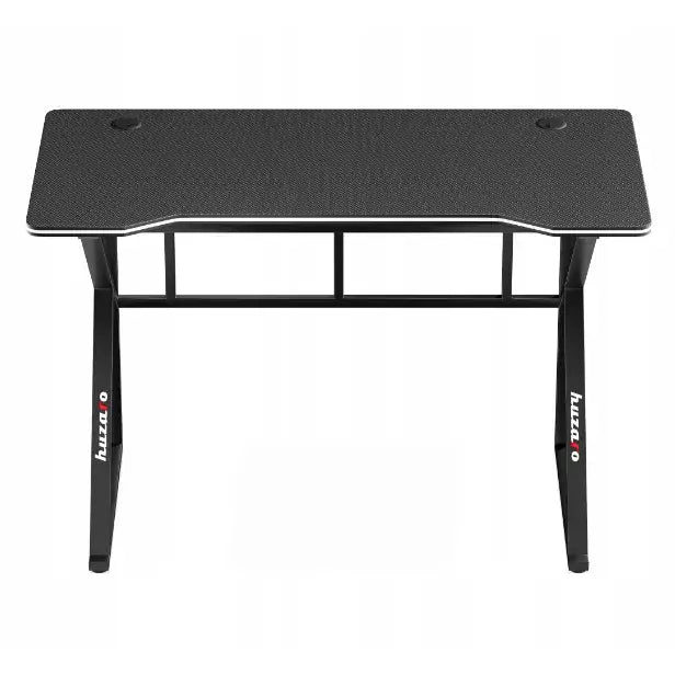 Gamingbord Huzaro Hero 1.6 svart, frontvisning med karbonfiber-overflate, to kabelhull og stabile metallben med logo.