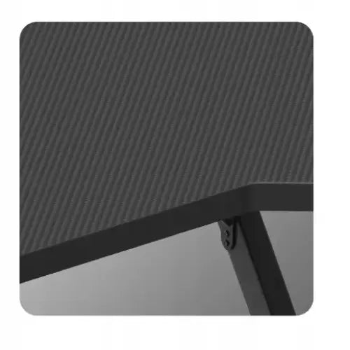 Gamingbord Huzaro Hero 2.5 RGB, nærbilde av svart karbonfiber-stil bordplate med avrundet hjørne og metallramme.