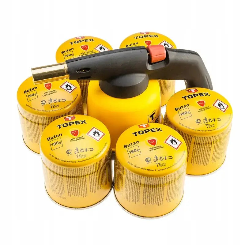 Gassloddingslampe med sort håndtak og messingdyse, omgitt av seks gule butangasspatroner, sett ovenfra.