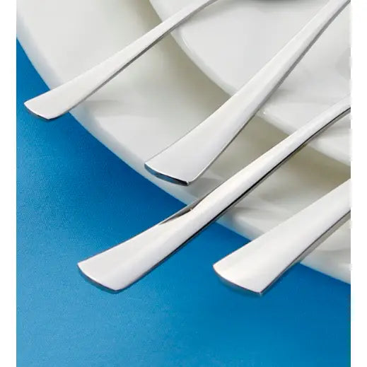 Fire blanke Gerlach Tunea skjeer i rustfritt stål, sidevisning på hvit tallerken mot blå bakgrunn.