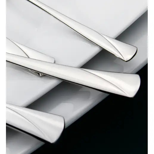 Gerlach Valor bestikksett, nærbilde av sølvfargede skaft med avrundet, moderne form på hvit tallerken.