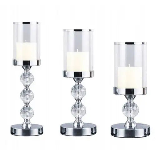 Glamour lysestaker sett med tre sølvfargede lanterner i ulike høyder, hver med hvitt kubbelys.