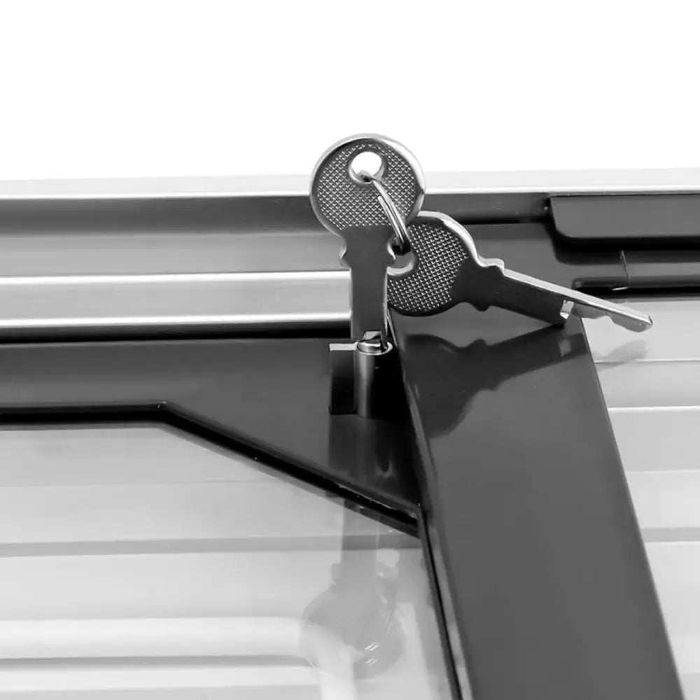 Nærbilde av to sølvfargede nøkler i lås på svart metallramme til glasset fryser for matvarer.