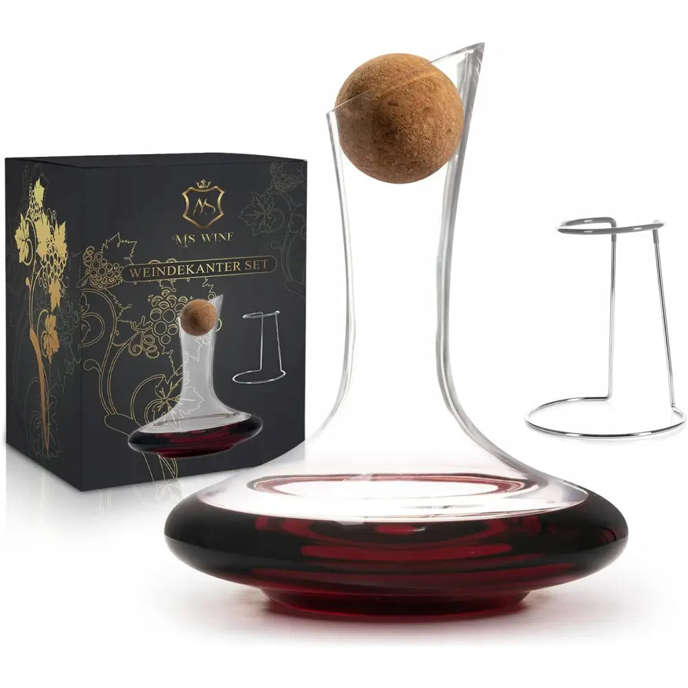 Glasskaraffel for vin med bred bunn, fylt med rød vin, korkkule, metallstativ og gaveeske, skrå vinkel.