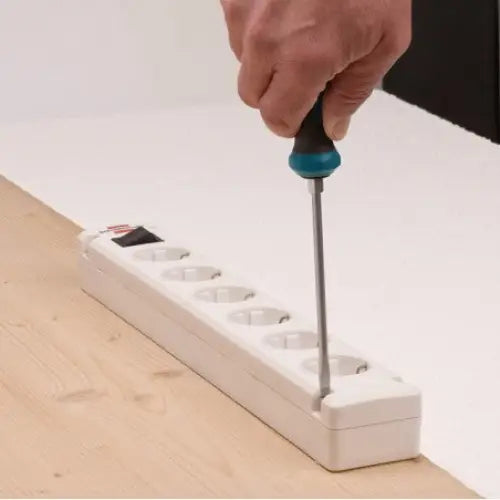 Grenuttak Bremounta, seks uttak monteres med skrutrekker på lyst trebord, nærbilde av installasjon.