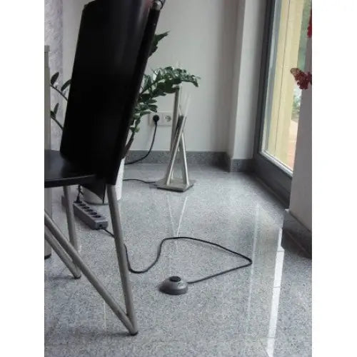 Grenuttak Eco-Line Comfort Switch 6-veis med rund fotbryter foran svart stol på grått gulv.