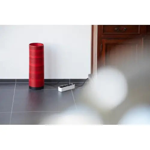 Grenuttak Ecolor 5-veis hvit/svart, tilkoblet kontrollboks på mørkt gulv foran hvit vegg.