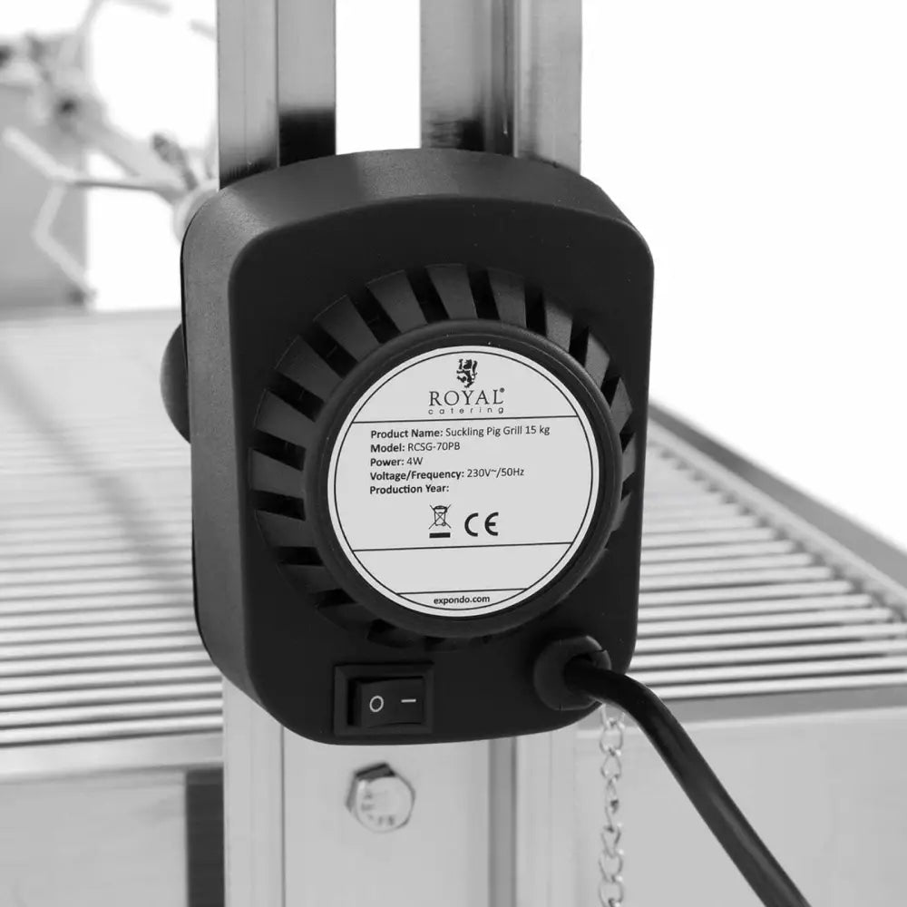 Elektrisk motorenhet til grillspidd, nærbilde bakfra med synlig etikett og strømbryter montert på metallrister.