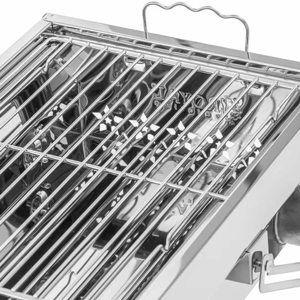Sammenleggbar grill med rist, nærbilde av rustfri grillrist med håndtak og luftespalter fra skrå vinkel.