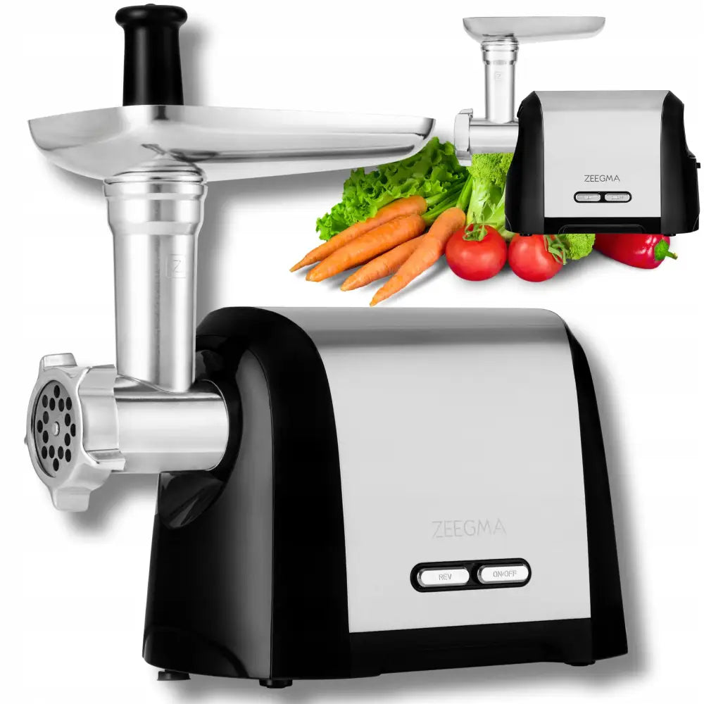 Grønnsakskutter og kjøttkvern i stål og svart plast, sidevisning med grønnsaker og tilbehør i bakgrunnen.