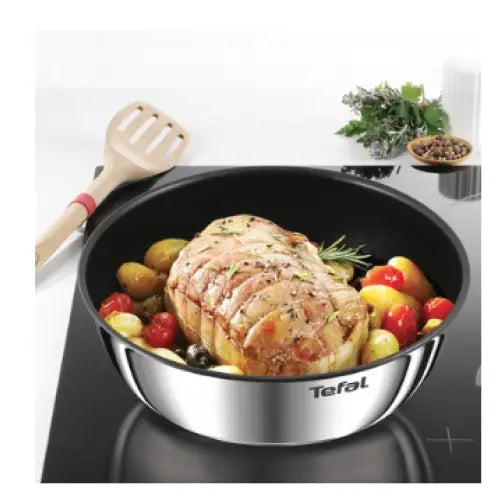 Stekepanne fra Ingenio Emotion sett, fylt med stek, poteter og grønnsaker, sett ovenfra på sort kokeplate.