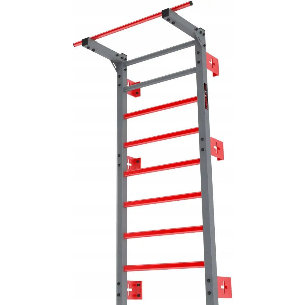 Ribbevegg ZIDER SPORT i grått metall med røde tverrstenger og pull-up stang, sett fra lav vinkel.