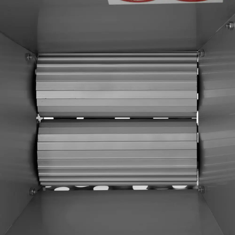 Handdrevet vingårdsavstryker og bærknuser, toppbilde av to sølv valser i metallkammer, sett ovenfra.