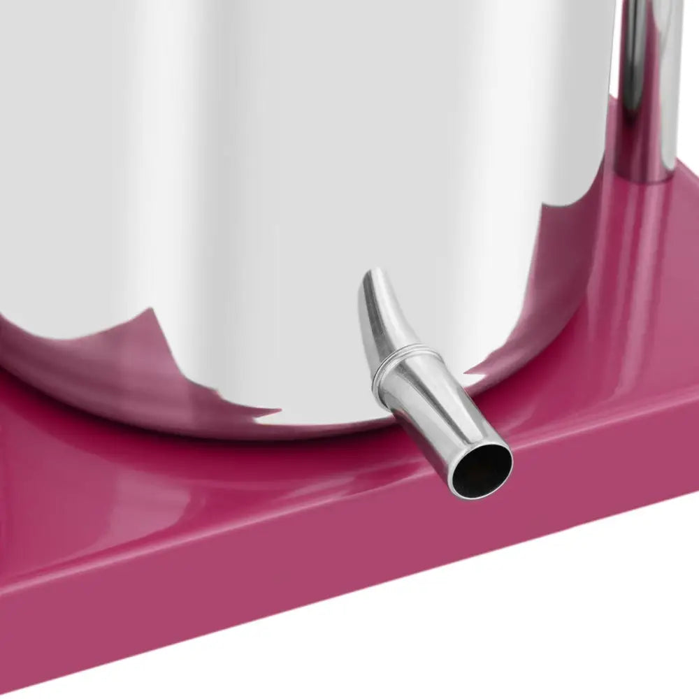 Håndholdt fruktvin juicepress, nærbilde av stålrør og tut med rosa base og sylindrisk beholder.