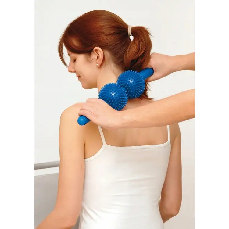 Håndholdt spiky massasjerulle med to blå kuler brukes på nakken, sett bakfra på kvinne.
