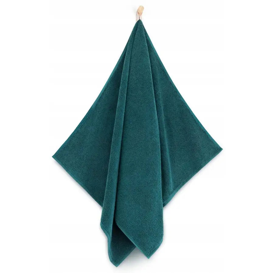 Mørkegrønt bomullshåndkle Zwoltex Kiwi, henger fra krok, sett forfra med enkelt design.