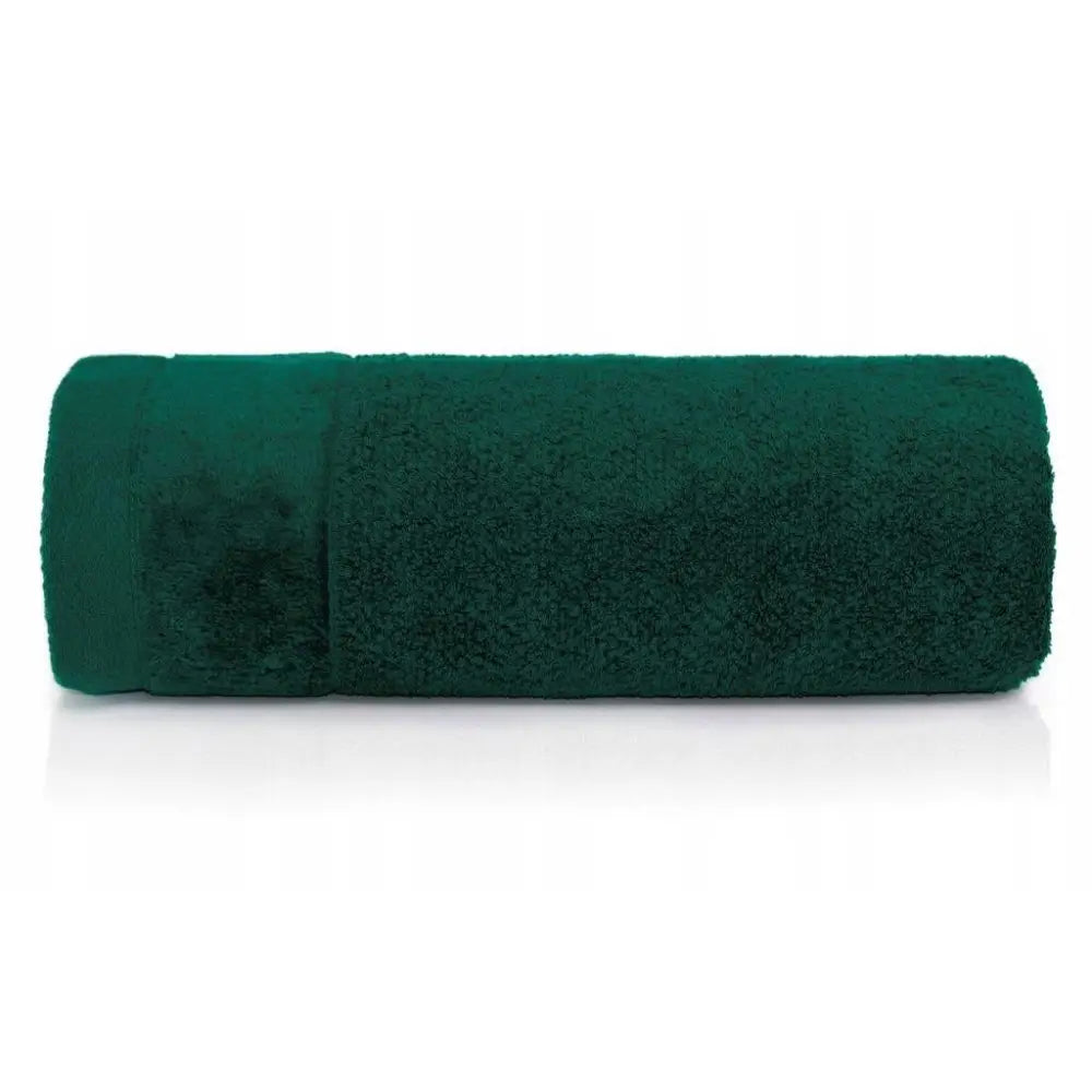 Håndkle Vito Sauna Spa i mørkegrønn frotté, rullet sammen og vist fra siden med myk tekstur.