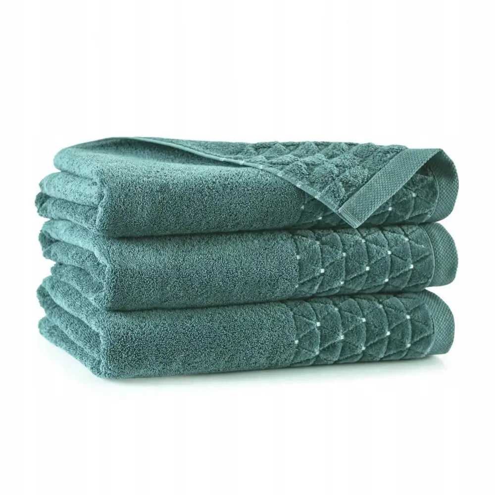 Mørkegrønt Oscar håndkle 70x140 cm, tre sammenbrettede med rutemønster langs kanten på hvit bakgrunn.