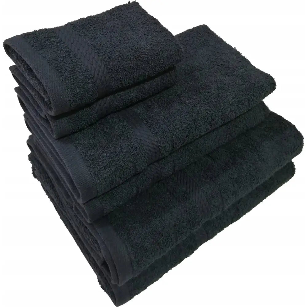 Håndklepakke i svart, fire størrelser stablet med dekorbånd og myk frottétekstur synlig i kanten.