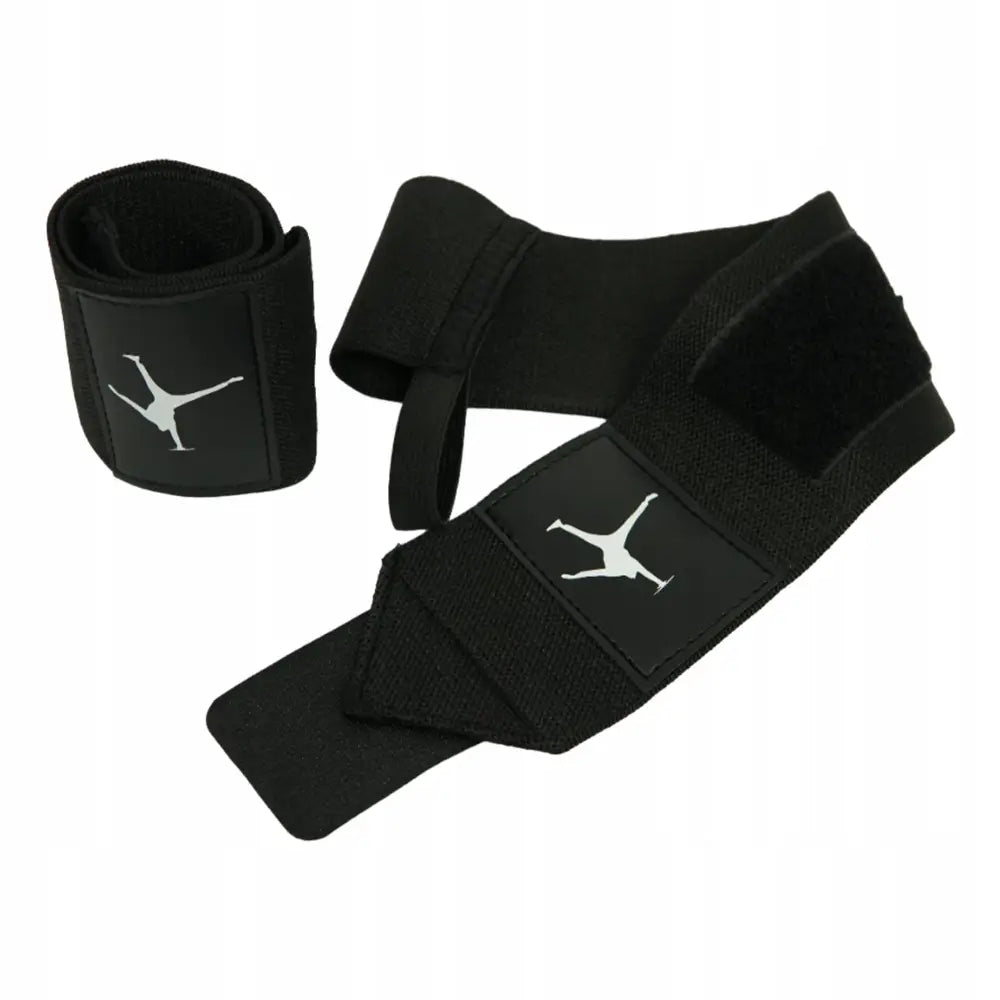 Håndleddsstabilisator Kura Sport, sort elastisk støtte med hvitt akrobatmotiv og borrelås, utstrakt og rullet.