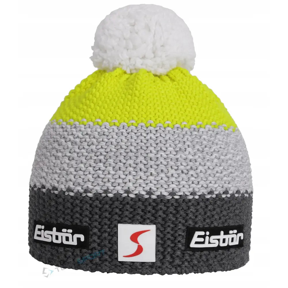 Herre vinterlue i merinoull med gul, grå og mørk grå fargeblokker, stor hvit dusk og to logoetiketter.