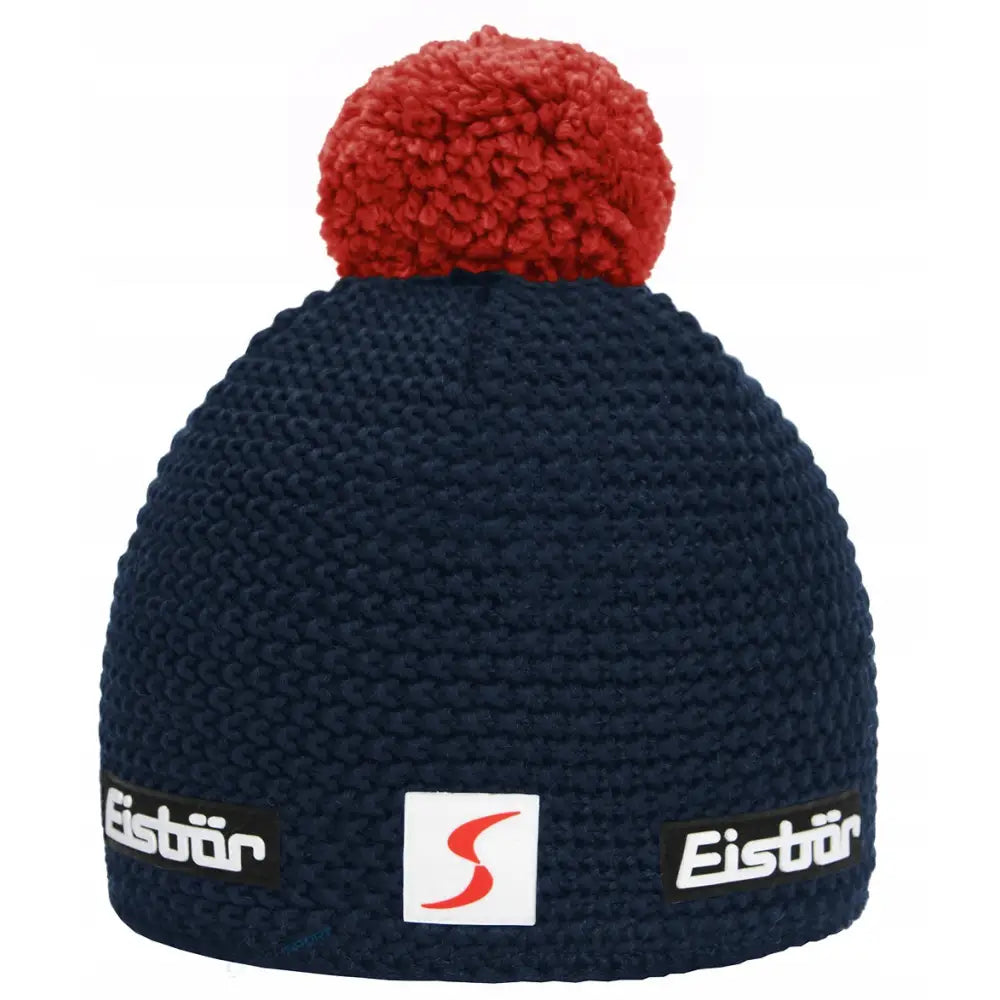 Herre vinterlue i mørkeblått, sett forfra med stor rød dusk og tre merkeetiketter foran på luen.