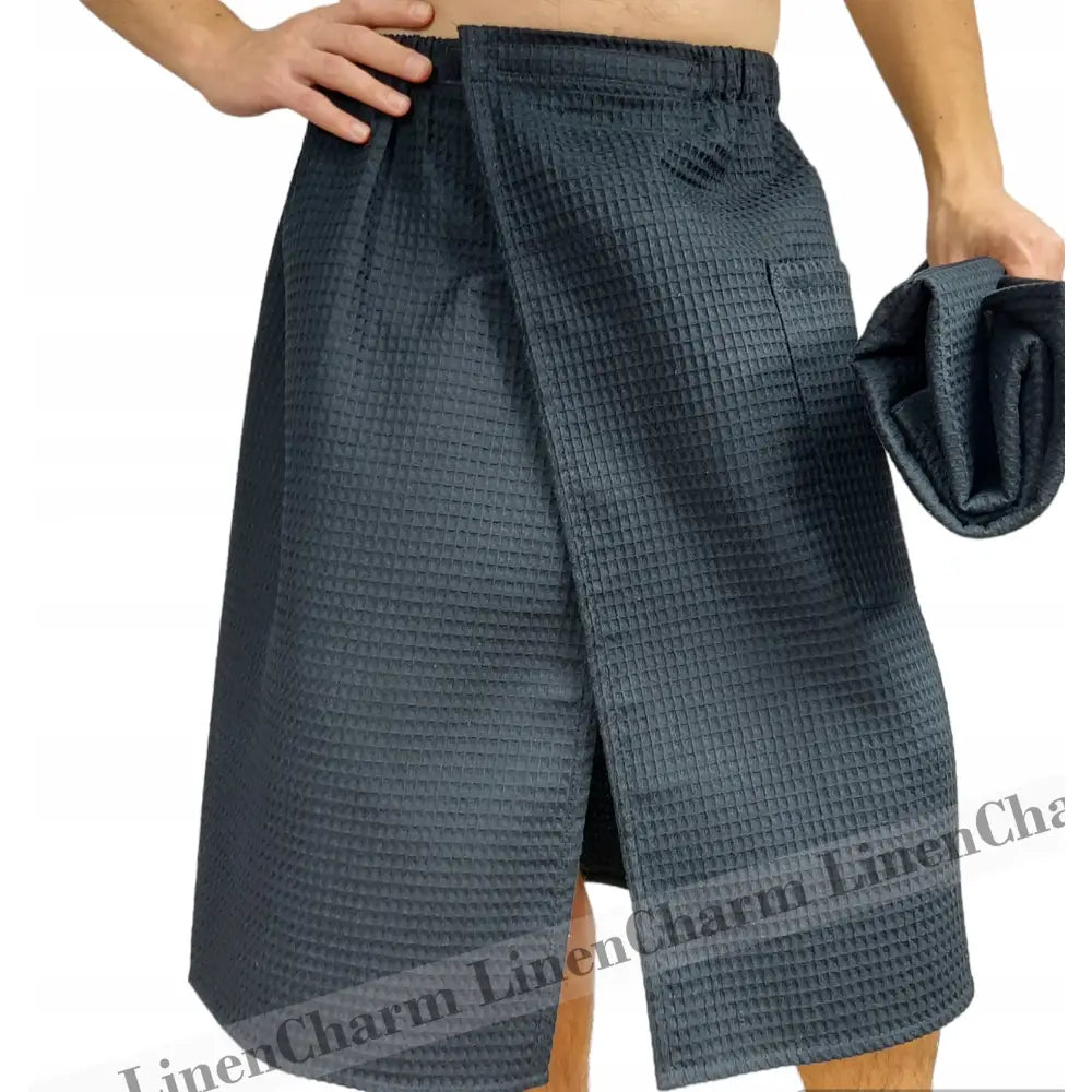 Herreset kilt i mørkegrå vaffelbomull, frontvisning på modell med matchende sammenbrettet håndkle i hånden.