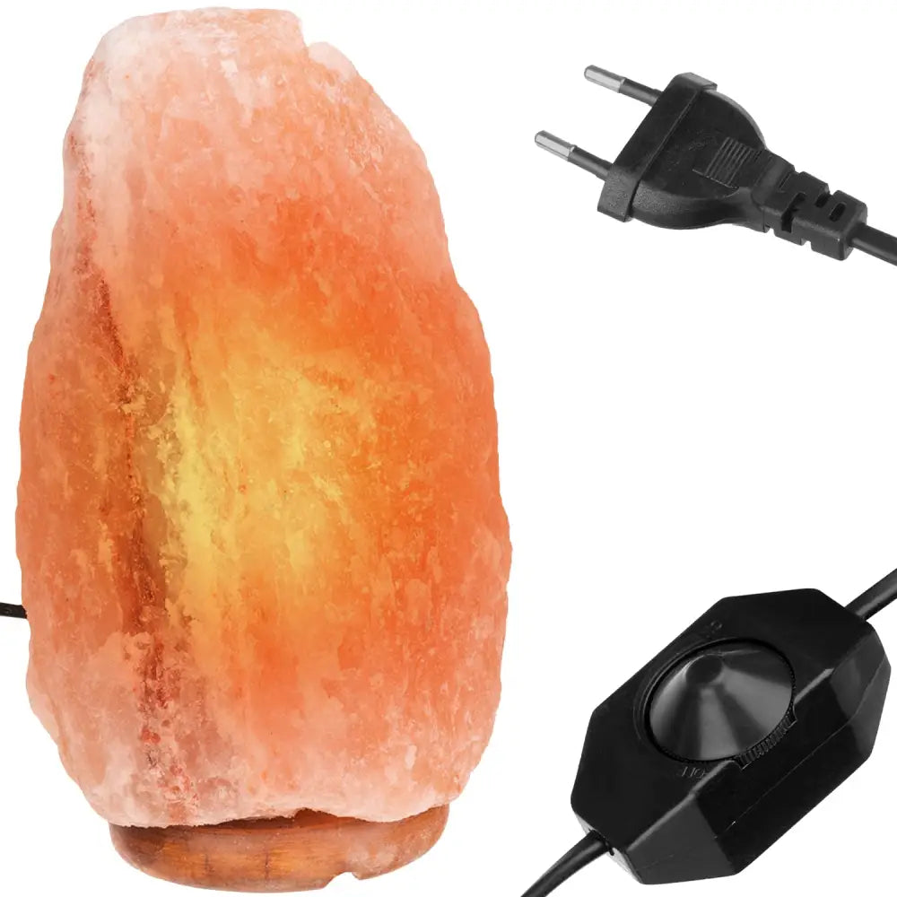 Himalayasaltlampe i naturform på rund trefot, sett fra siden med synlig dimmer, ledning og støpsel.