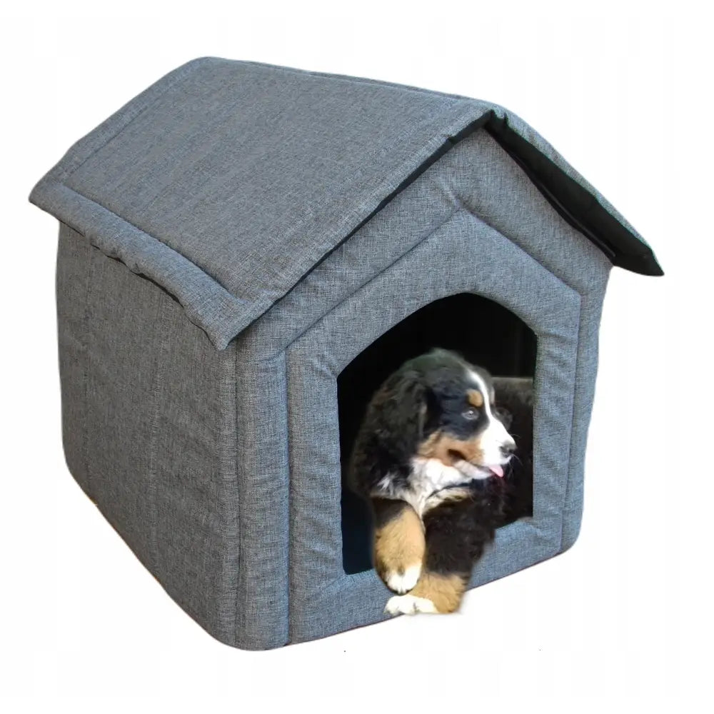 Hjemmelaget hundehus for store hunder i grå tekstil med skråtak, hund hviler inne med hodet ut av åpningen.