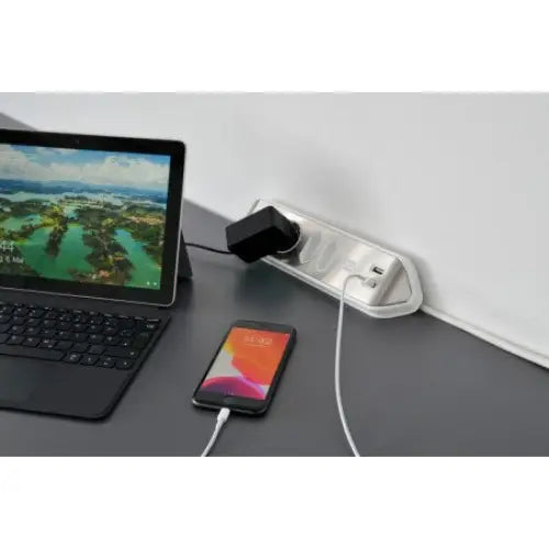 Hjørneuttak estilo med fire stikk og to USB, skrå sidevisning med nettbrett og mobil tilkoblet for lading.