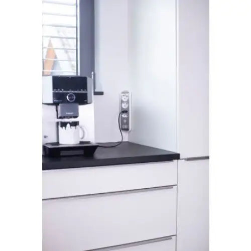 Hjørneuttak Estilo V2, hvitt stikkontaktpanel med fire uttak og to USB, montert i kjøkkenhjørne.