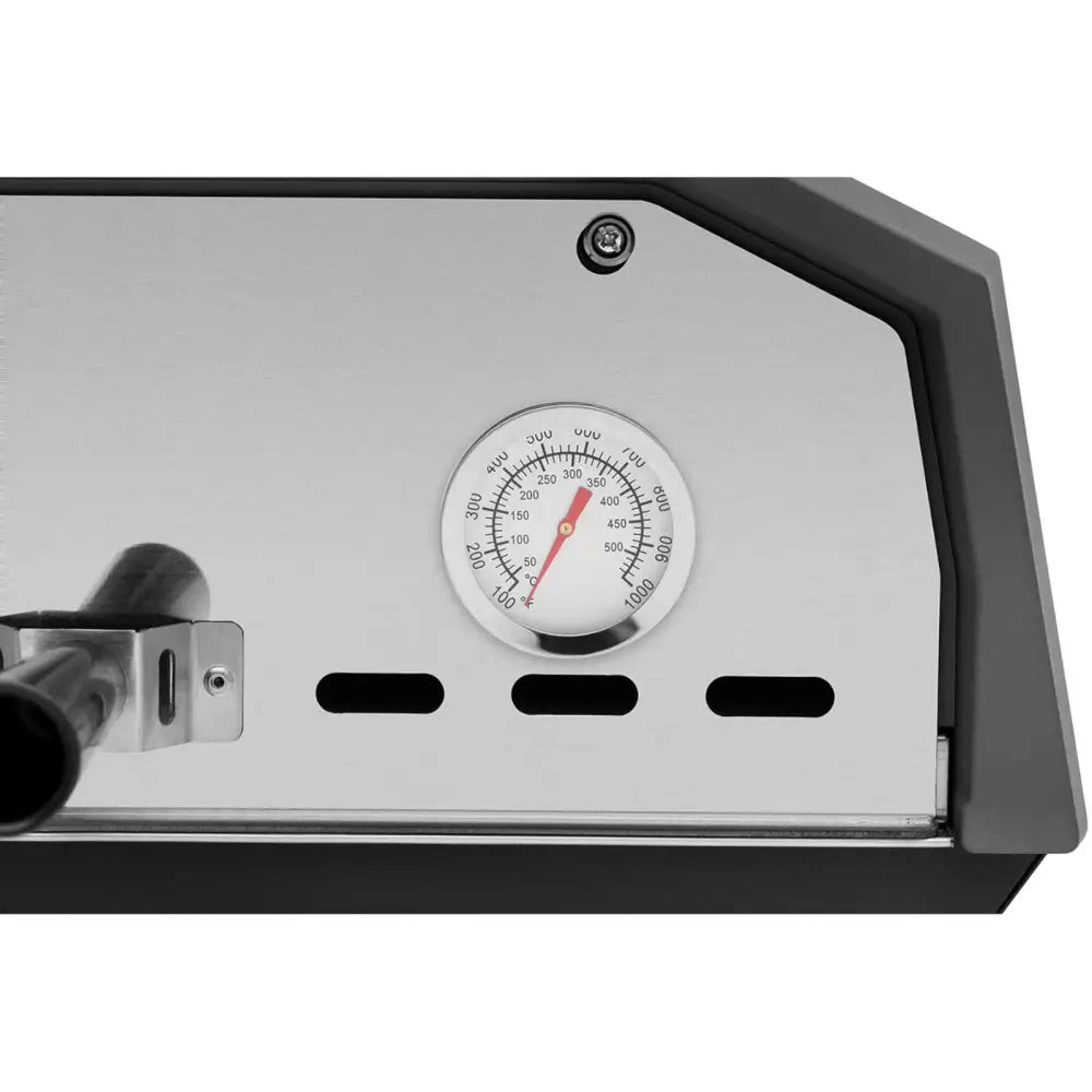 Rustfritt stålpanelet på pizzaovnen med analogt termometer, ventilasjonshull og sort håndtak til venstre.