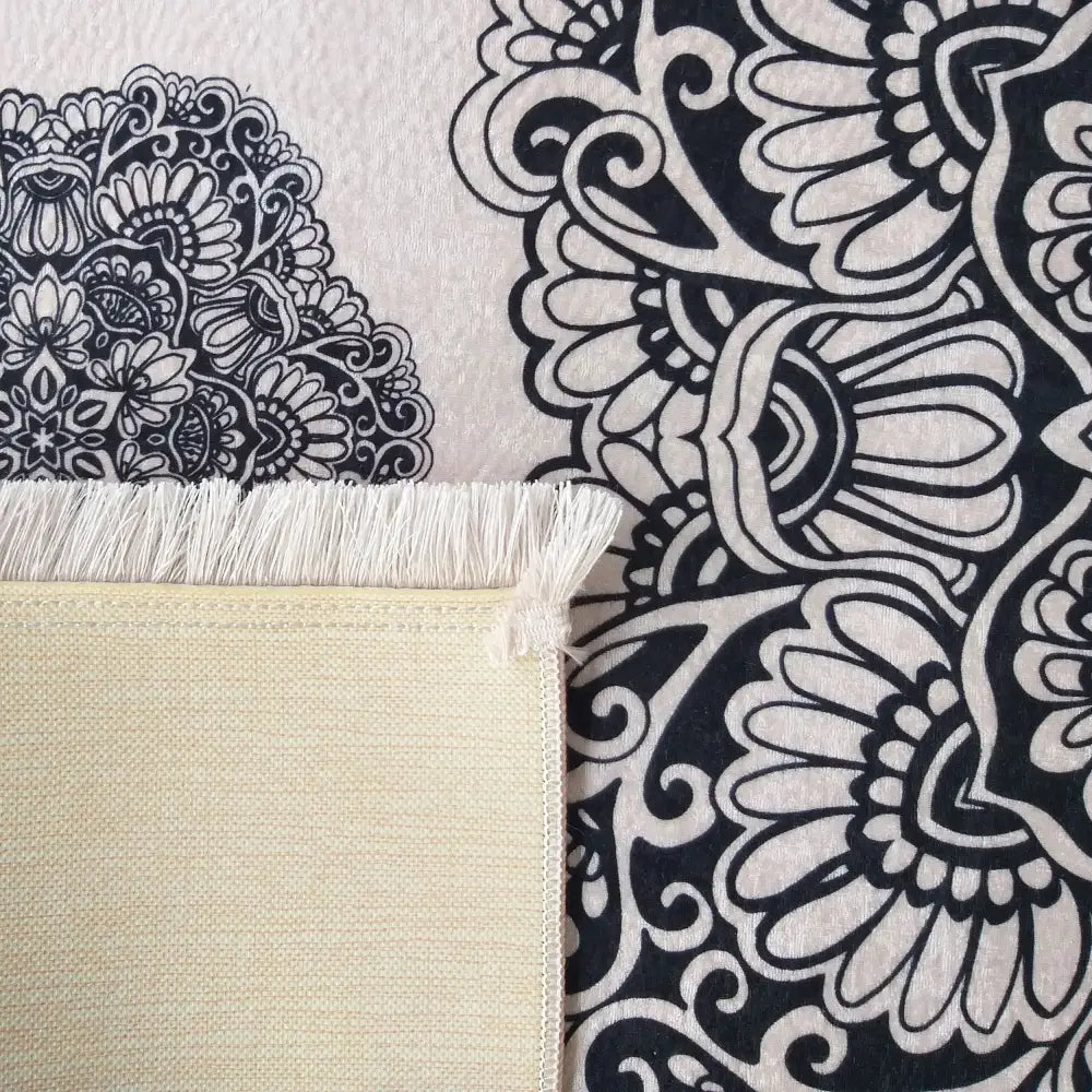 Horeca 10 Pudra Tepe, nærbilde av lys beige teppe med sorte blomster, frynser og synlig bakside.