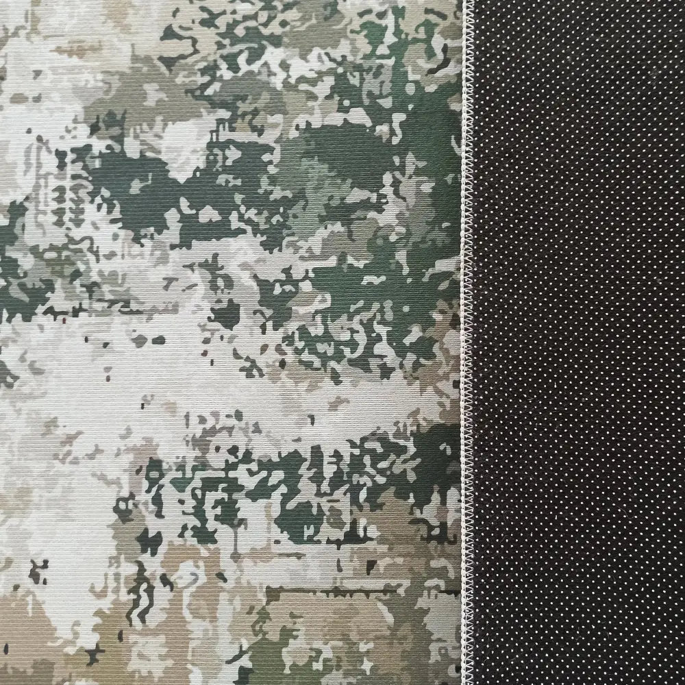 Grønn Tepe tekstil, nærbilde av camouflagemønstret panel og mørkt panel med hvite prikker, tydelig søm.