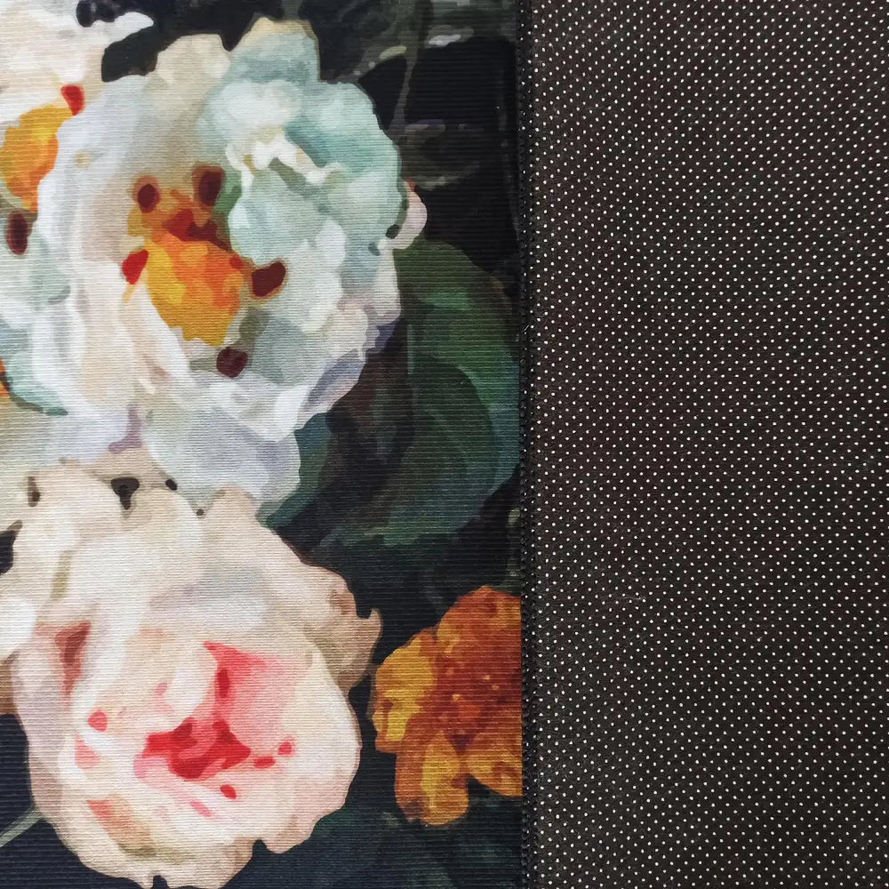 Nærbilde av HORECA Nytt Svart Tepe med lyse blomster til venstre og sort prikket stoff til høyre.