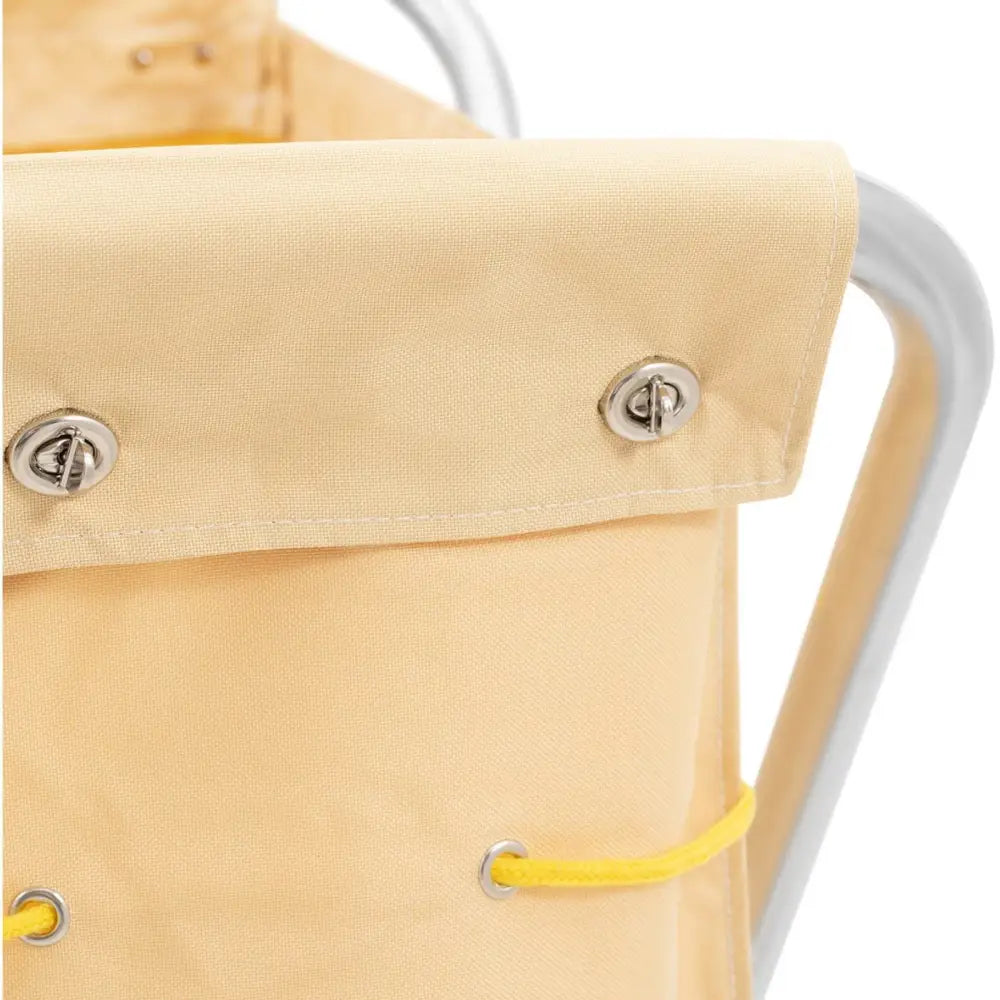 Hotellvogn for sengetøyvask, nærbilde av beige, tettvevd tekstil med metallmaljer og gul snor.