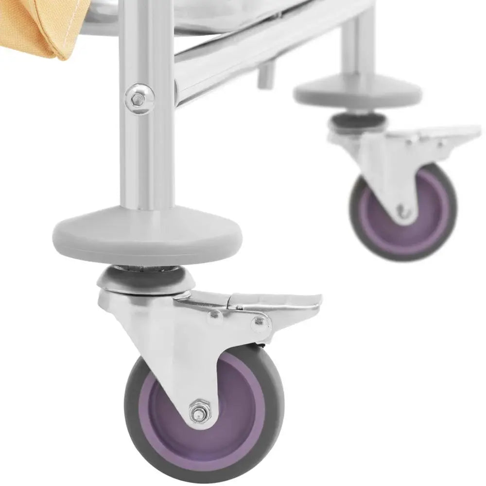 Hotellvogn for sengetøyvask, nærbilde av lilla hjul med brems og grått metallunderstell.