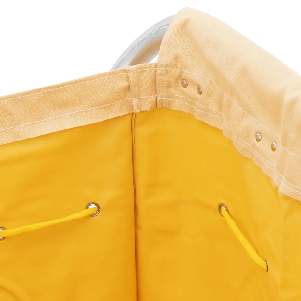 Hotellvogn for sengetøyvask, nærbilde av gul tekstil med snøring, metallmaljer og sølvfarget ramme.