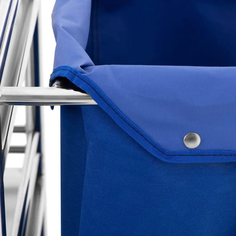 Detaljbilde av blått tekstil med trykknapp festet til solid metallramme på hotellvogn for vask.