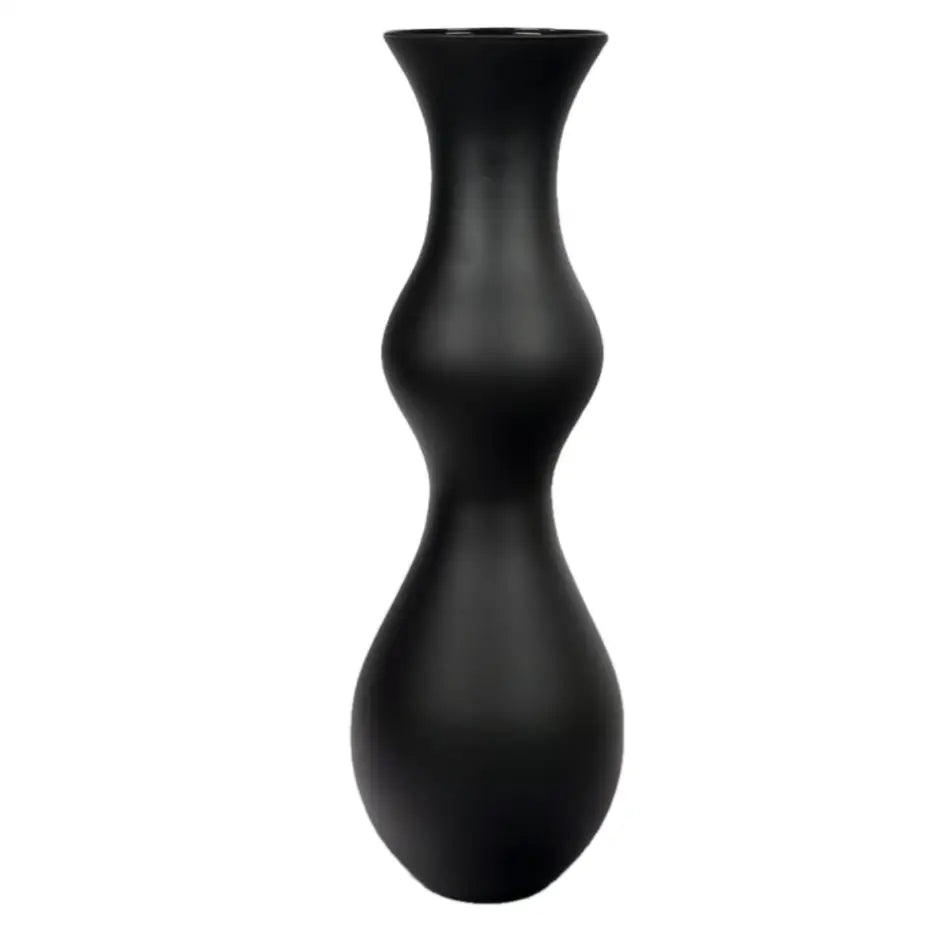 Høy vase i matt svart keramikk med timeglassform, minimalistisk design sett forfra mot hvit bakgrunn.