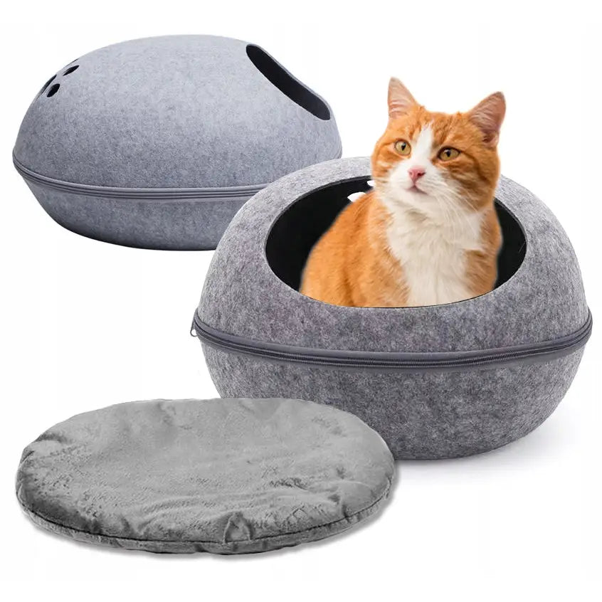 Rund grå kattehule i filt med avtagbar pute, katt sitter komfortabelt inne og ser ut av åpningen.